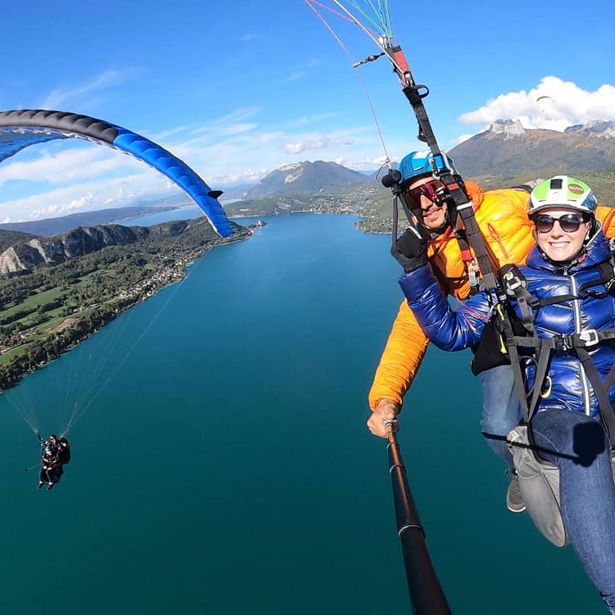 Survol en parapente avec vue sur les lacs et montagnes en Haute-Savoie.