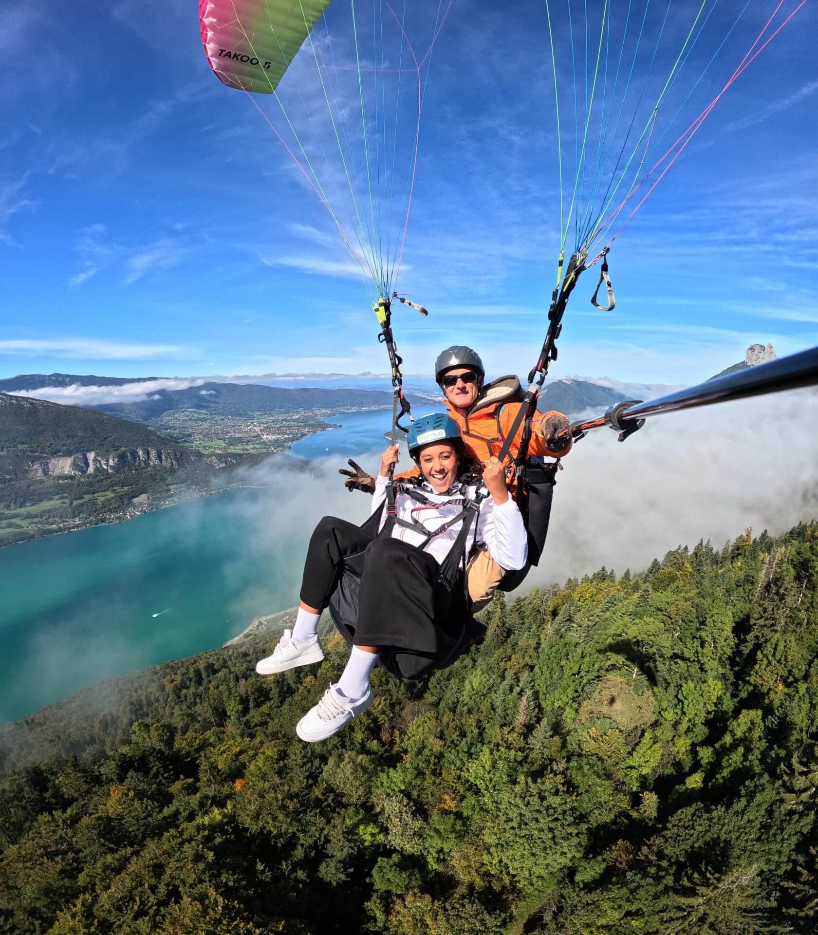 Première expérience en parapente biplace avec vue sur le lac d'Annecy et les montagnes environnantes.