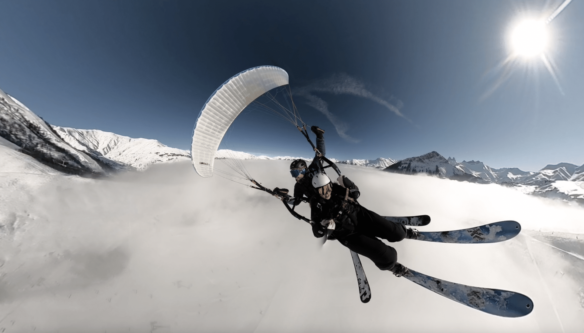 Vol en parapente hivernal au-dessus de la station du Corbier dans le domaine des Sybelles.